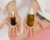 mãos femininas mostrando 2 produtos de skincare. niacinamida e vitamina c - um produto em cada mão.